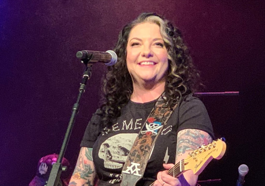 Ashley McBryde on stage playing guitar